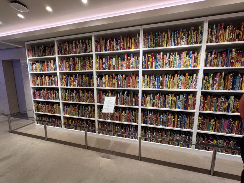 Shelf wall filled with colorful patterned books in a modern library setting. (Informative)