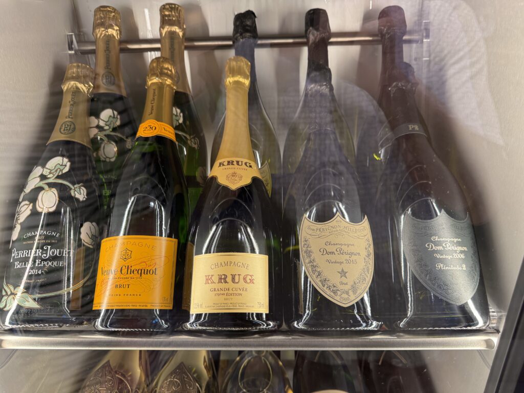 Row of champagne bottles in a cooler with labels facing forward, including Krug and Dom Pérignon.