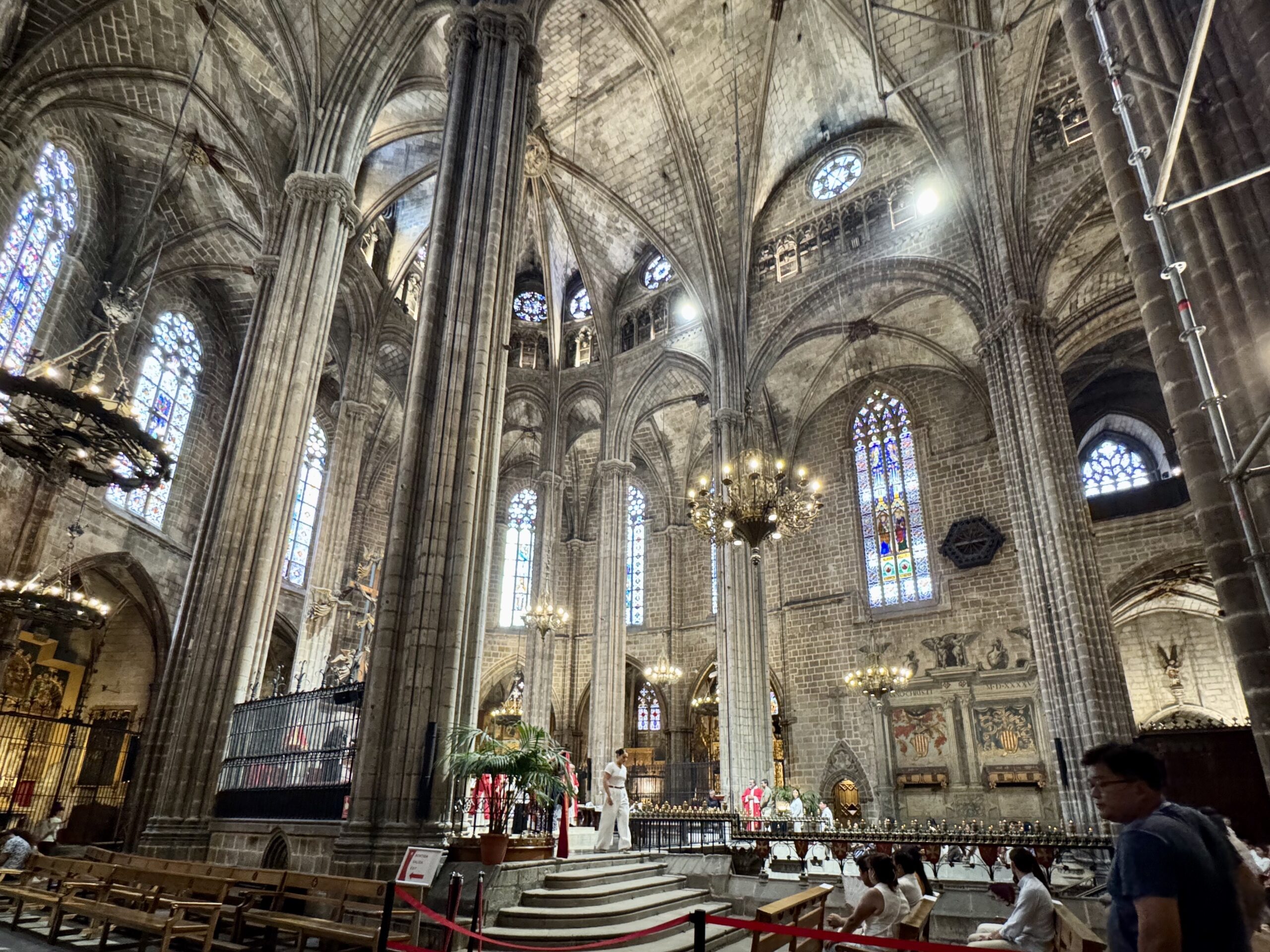 Interior of a Gothic cathedral with soaring stone columns, ribbed vaults, and colorful stained-glass windows. (informative)