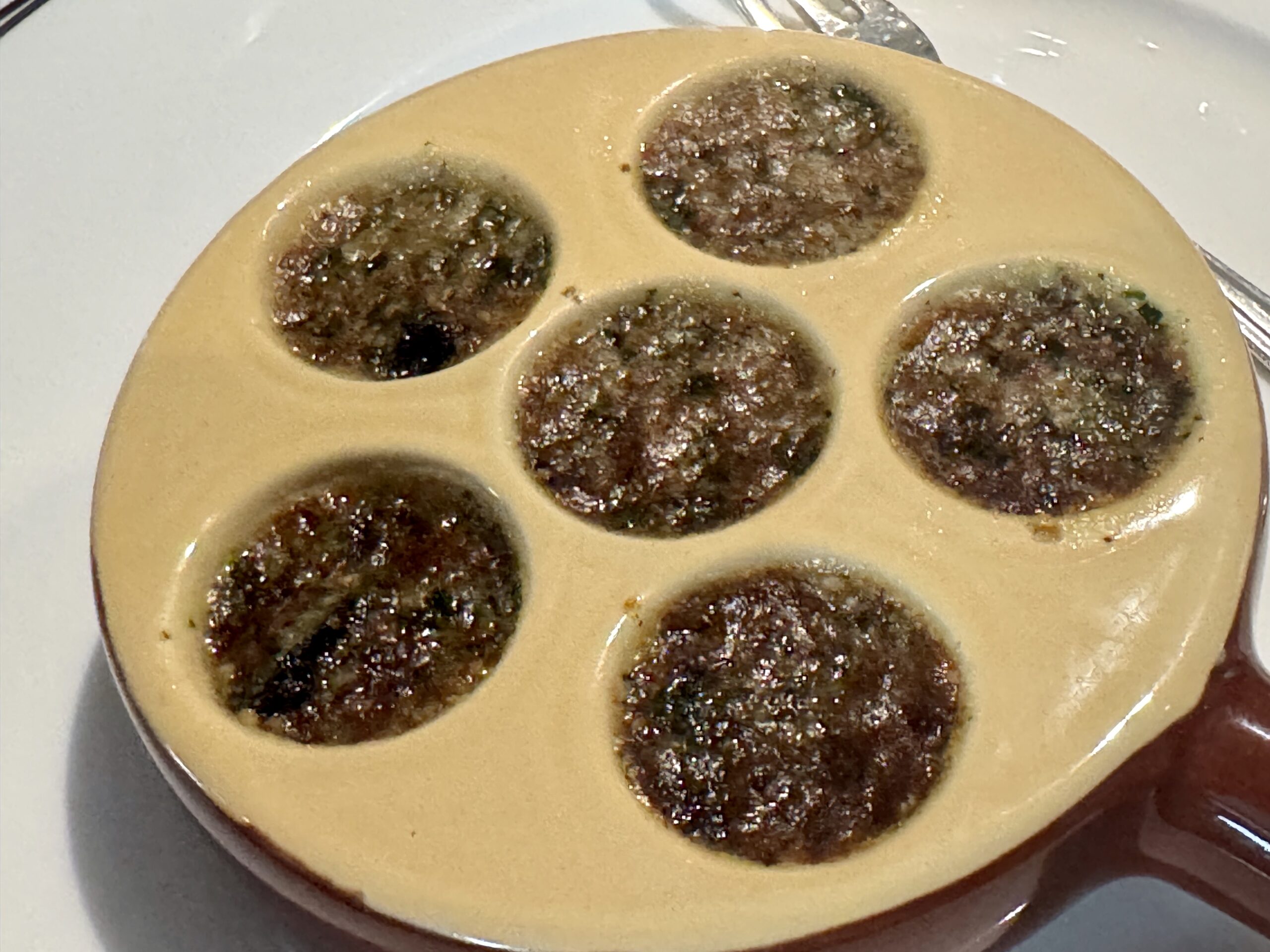 Beige circular mold with multiple brown crumb-filled wells on a plate.