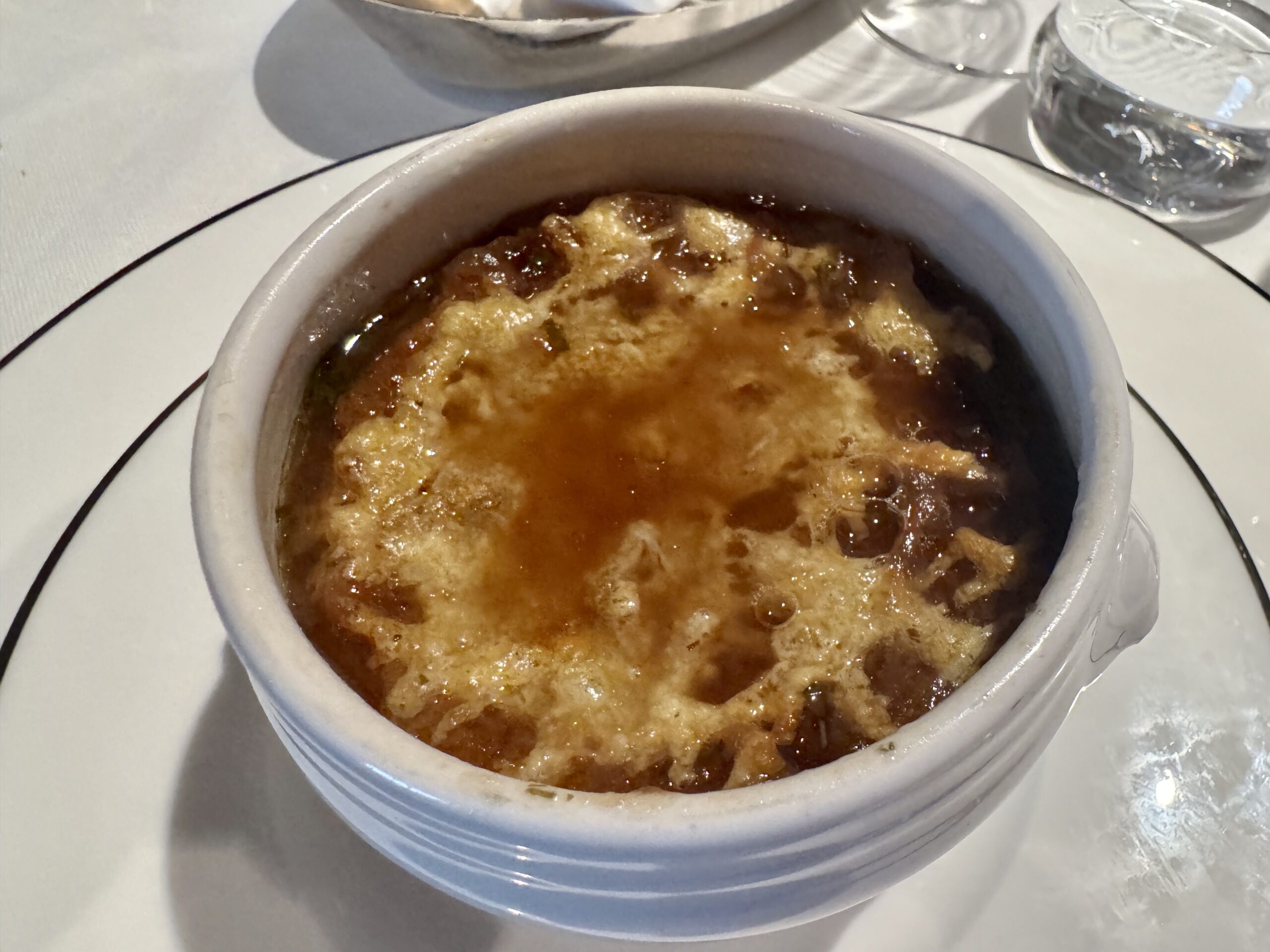 Close-up of a caramelized crème brûlée in a white ramekin on a dining table