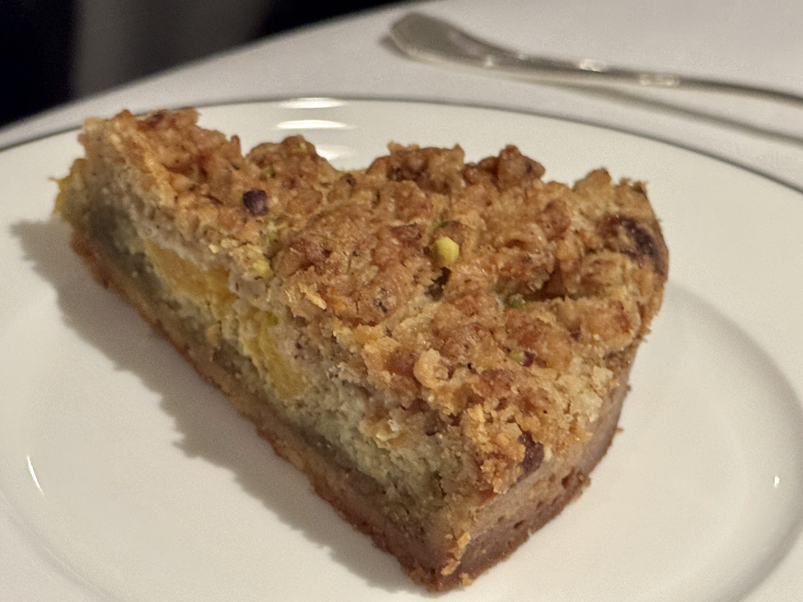 Slice of crumbly nut crumble bar on a white plate